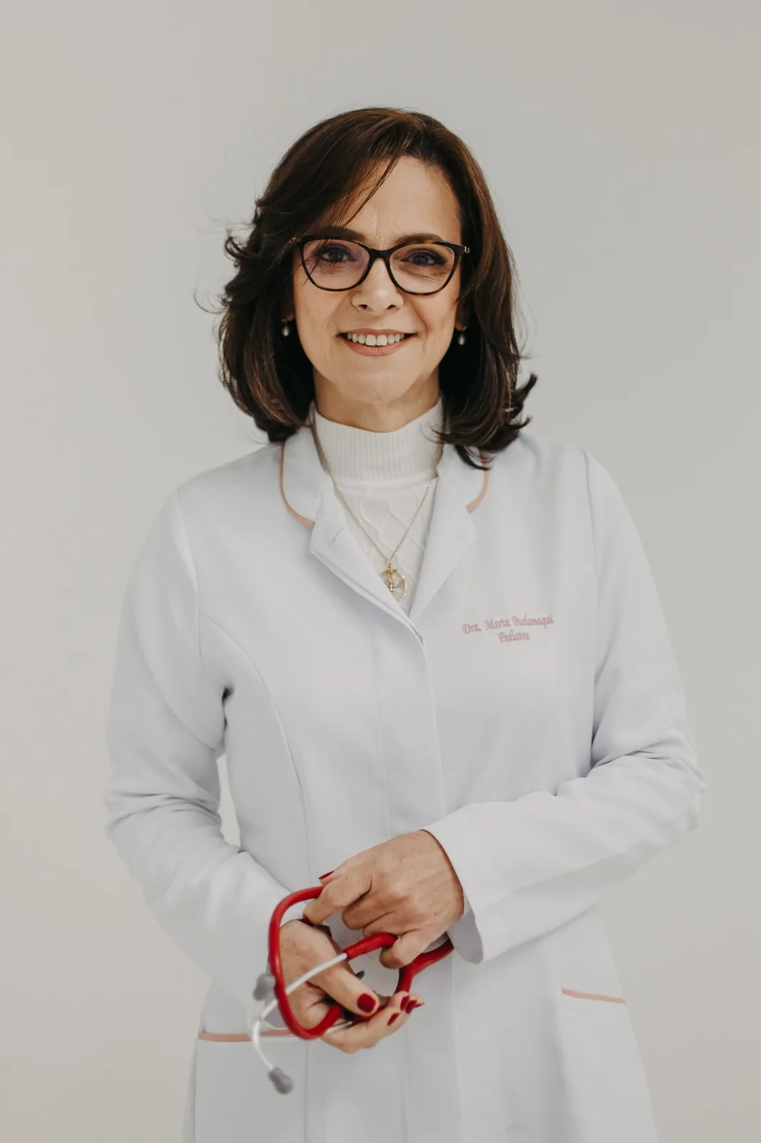Dra. Marta Burlamaqui de jaleco, com estetoscópio